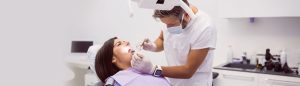 A lady having dental treatment from a dentist